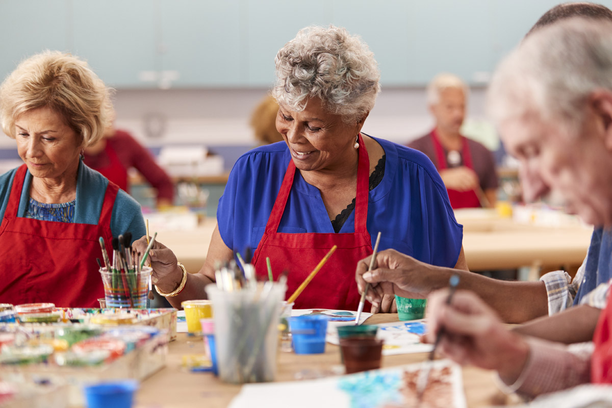  retired senior woman attending art class in assisted living