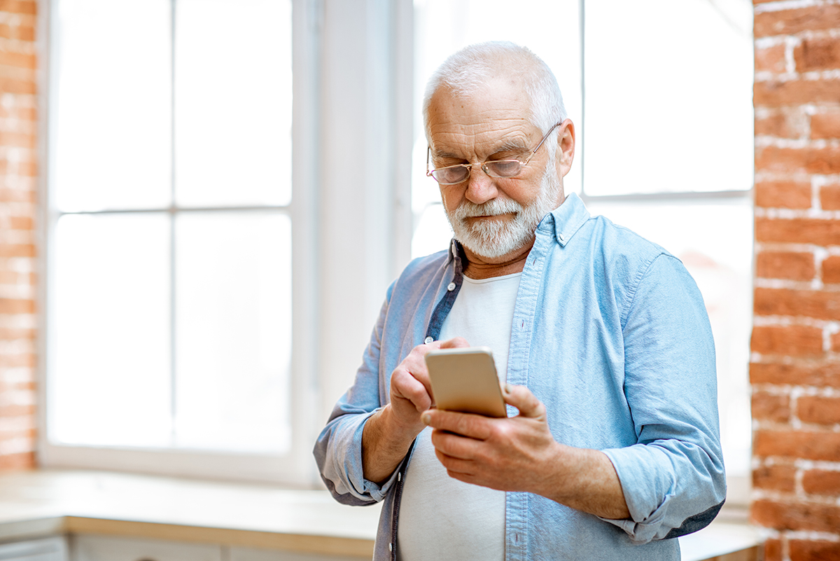 senior man with phone at home