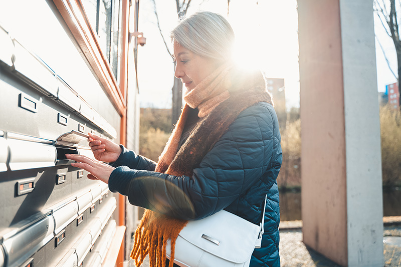 senior woman opens the mailbox to check for new ma 2022 06 28 13 27 28 utc